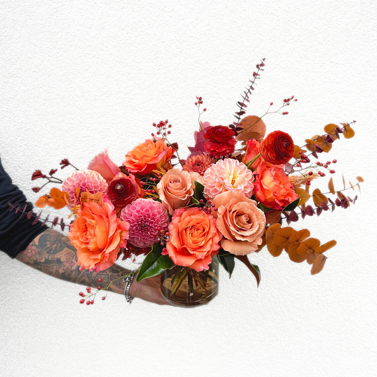 Bright arrangement of orange and peach roses, dahlias and ranunculus by The Flower Bar for a get-well delivery