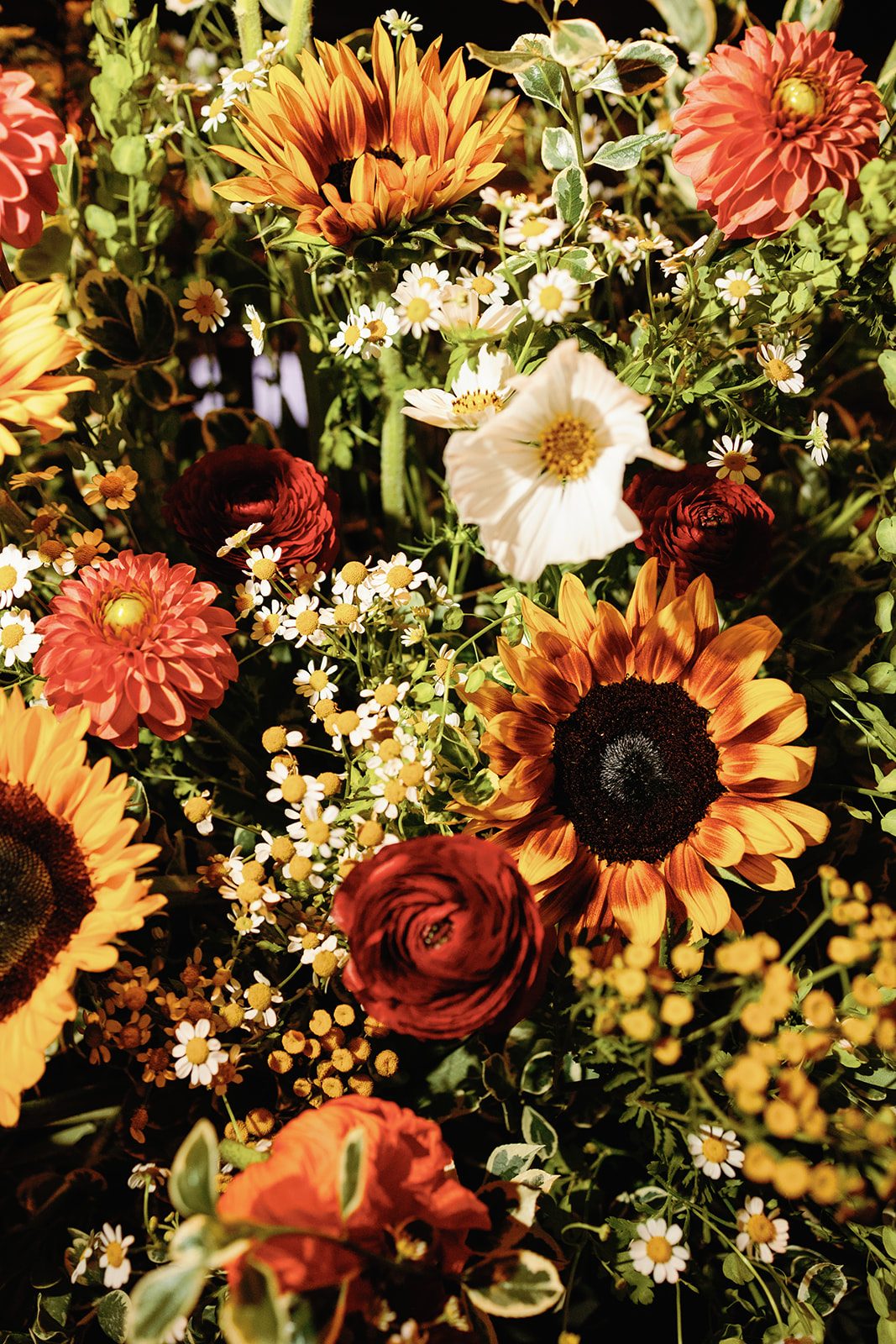Autumn flower arrangement of sunflowers, rust and burnt-orange dahlias, red ranunculus and chamomile, hand-designed by The Flower Bar in Larchmont, NY