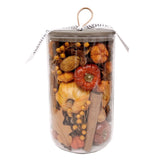 Clear cylindrical container filled with dried flowers and botanicals in orange, red, and natural tan tones with a wooden stem.