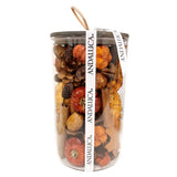 Clear cylindrical vase filled with dried flowers and botanicals in brown, orange, and red tones with an Andalucia branded ribbon.
