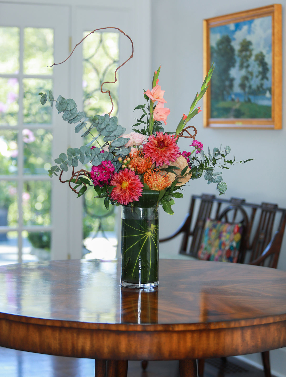 Colorful flower arrangement in a vase on a wooden table with a blurred background