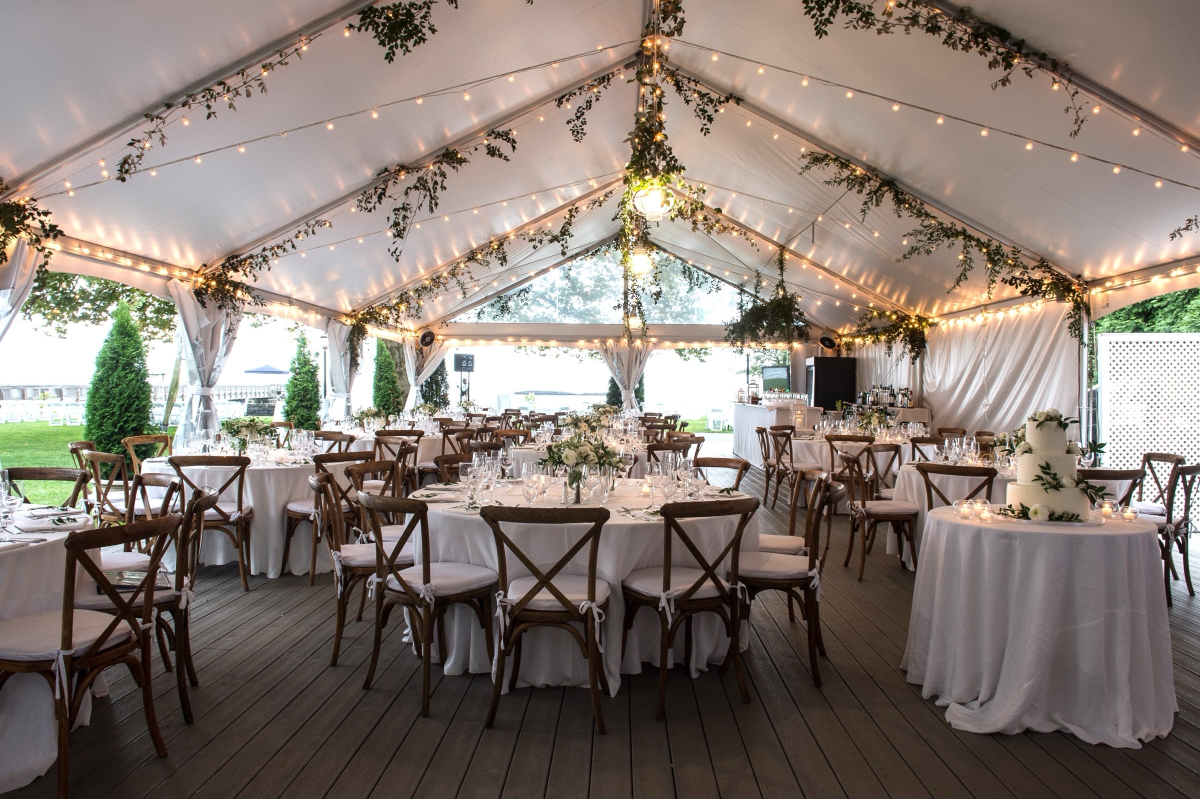 Wedding tent installation with hanging greenery and string lights designed by The Flower Bar, Westchester County wedding florist